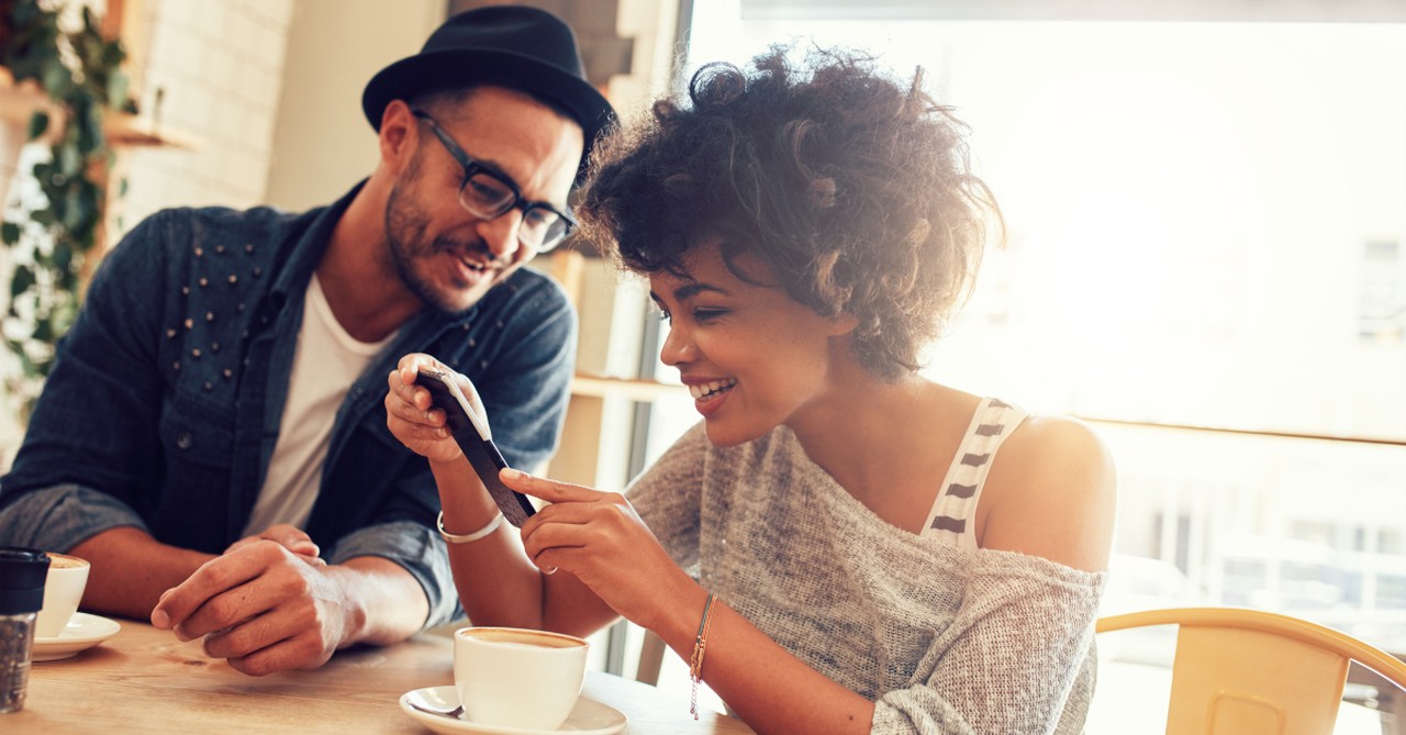 diverse friends laughing at tiktok or video on smartphone