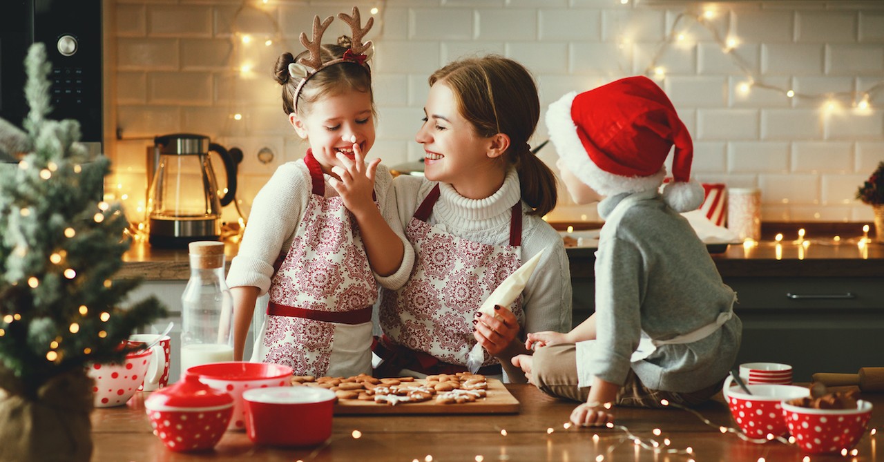 Happy mom and kids baking Christmas treats