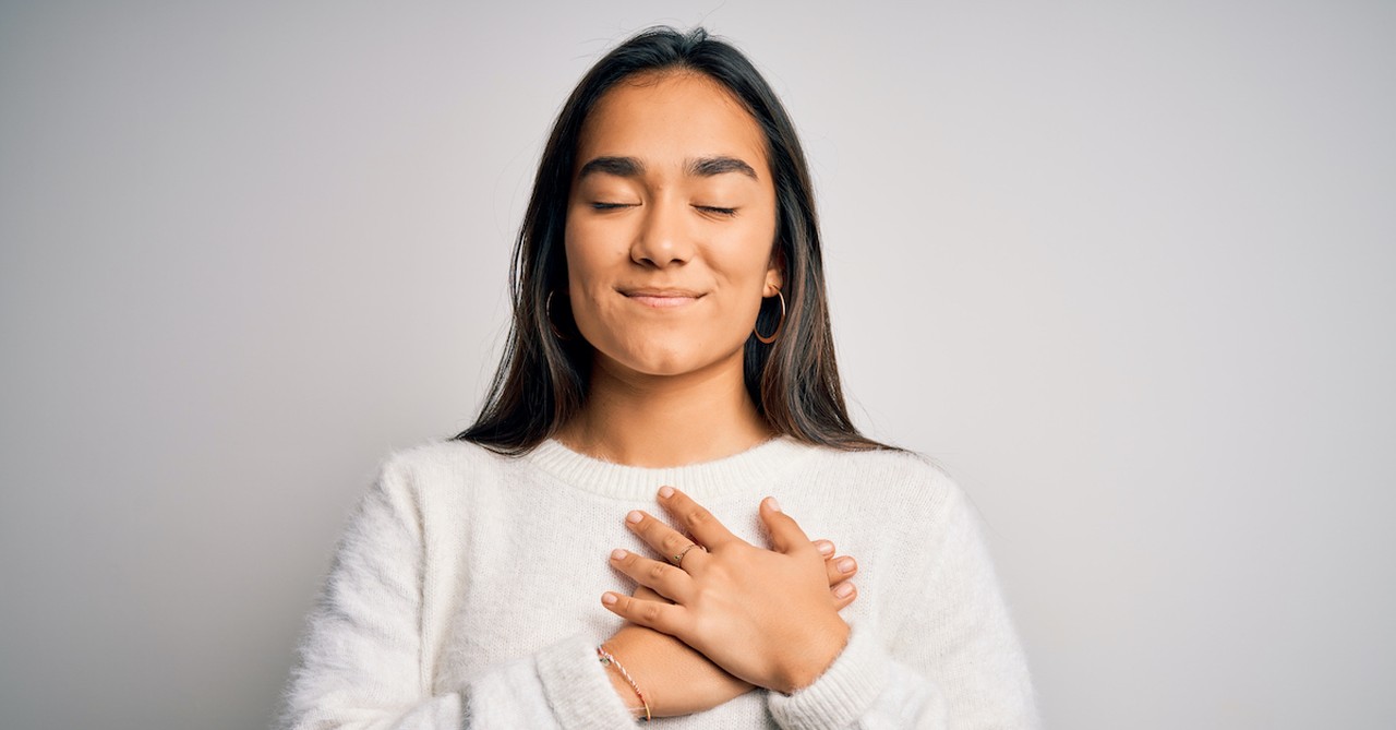 woman with hand over heart, thankfulness