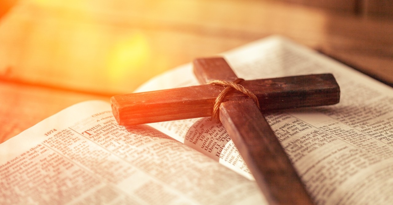 cross on a bible with sunlight