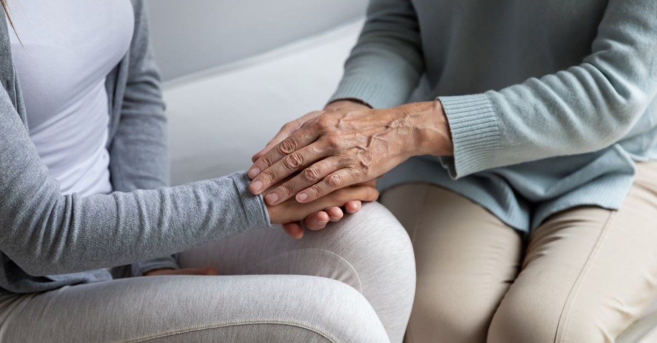 older parent holding adult child's hand