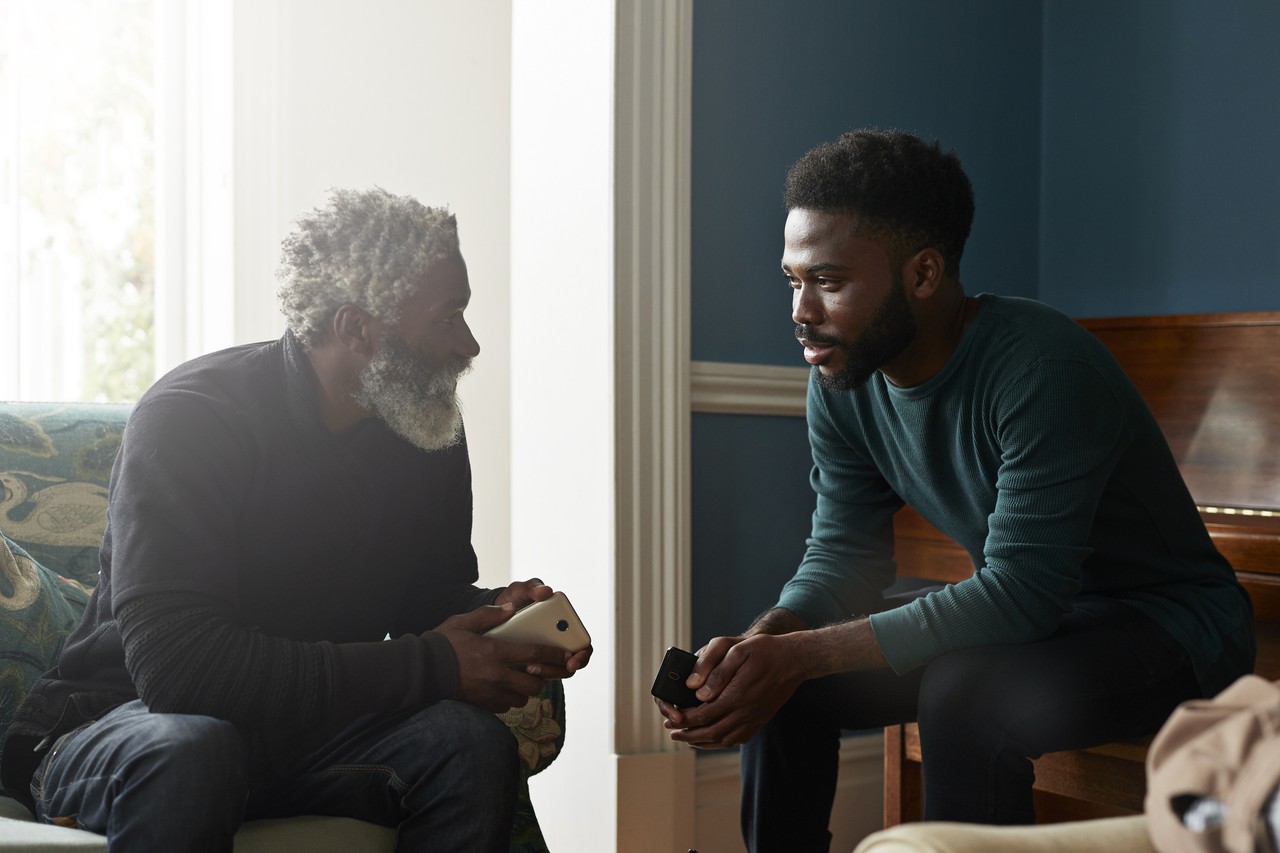 older father and son sitting in living room talking, honor your father and mother meaning