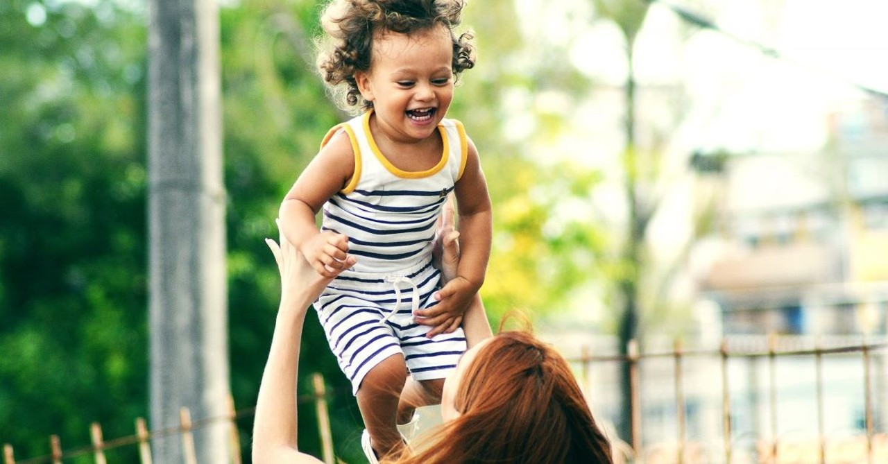 mother mom lifting child outside fun parent parenting single mom