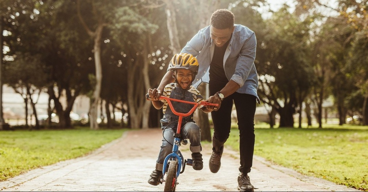 A father helping his son ride a bike