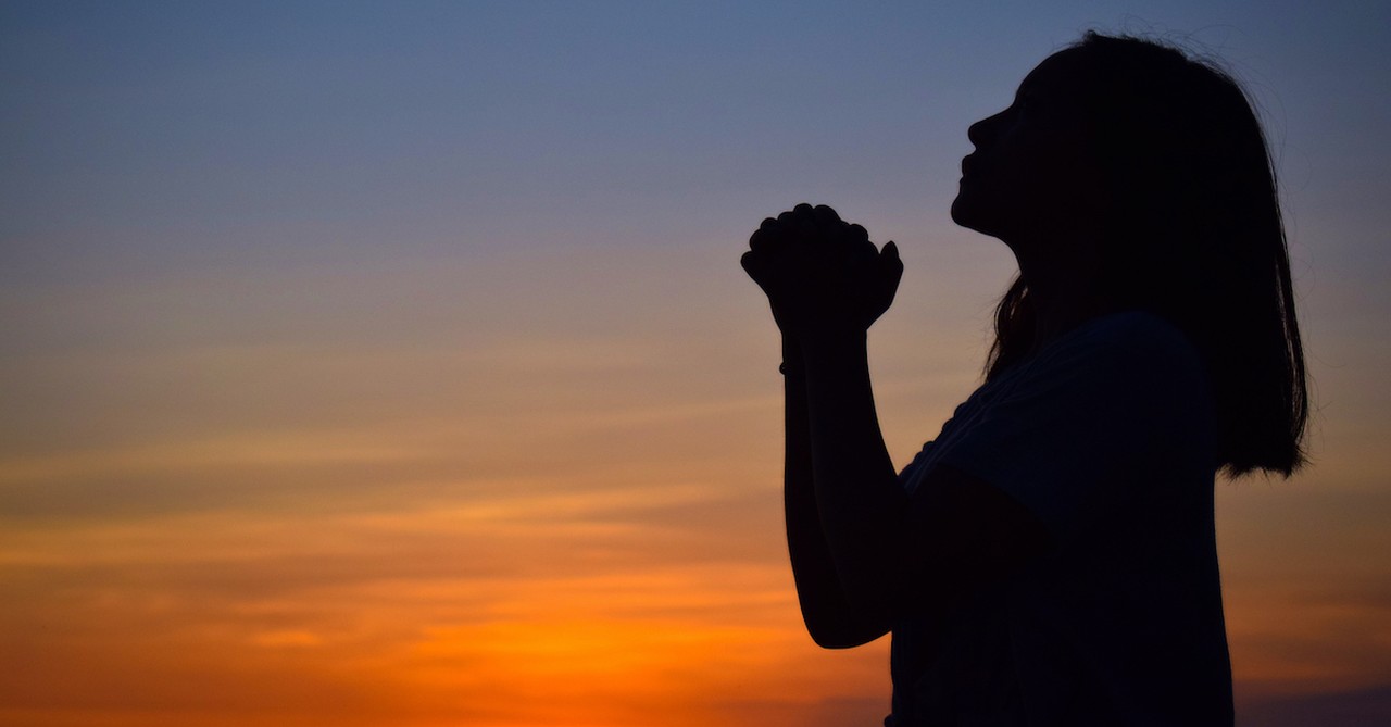 silhouette of woman praying at sunset, if God is for us who can be against us?