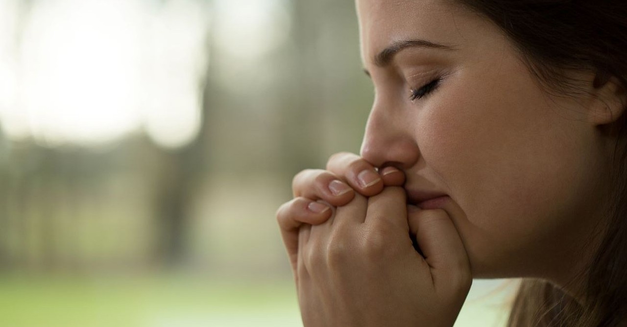 A sad woman crying and praying