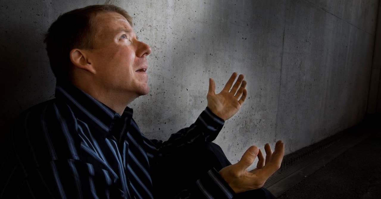 man sitting on floor looking up asking why upset confused angry sad