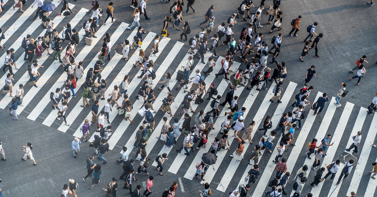 crowded crosswalk filled with people walking