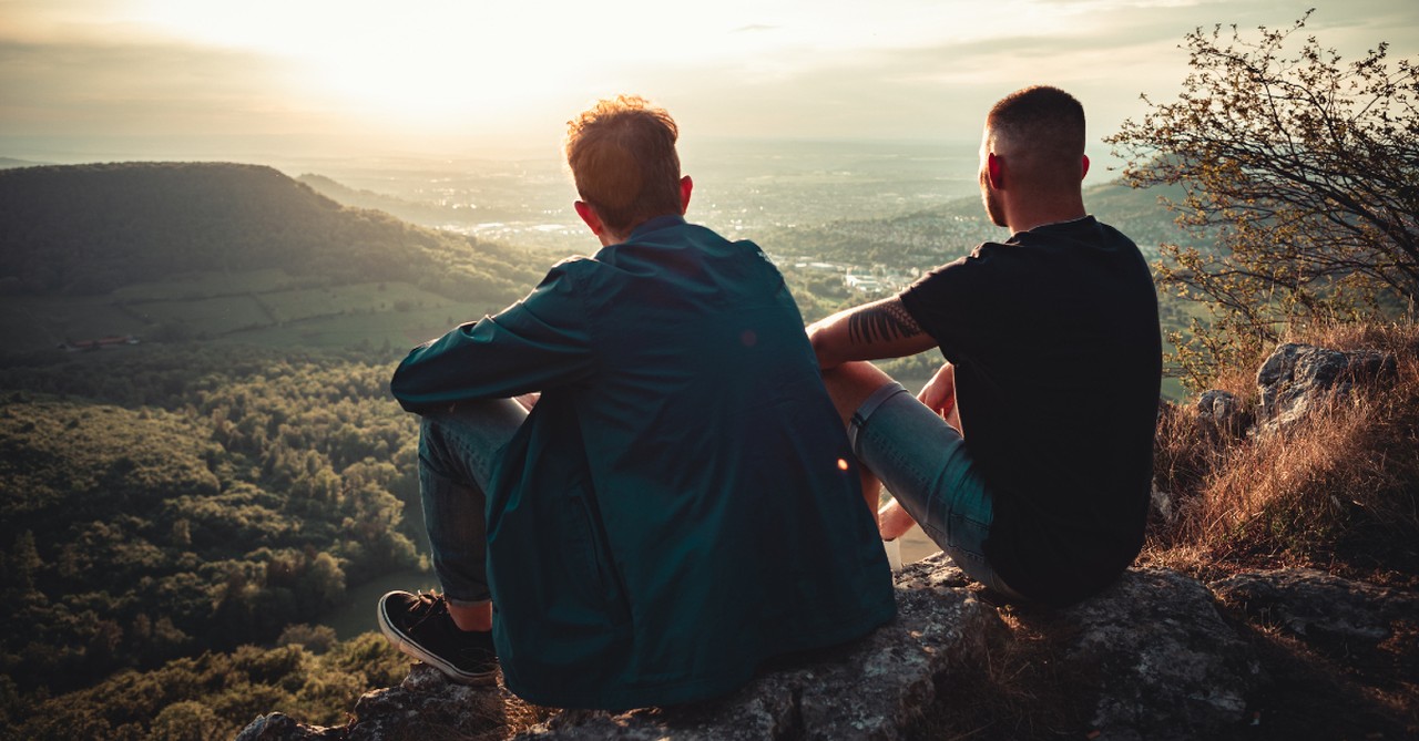 wo men sitting on mountain at sunset