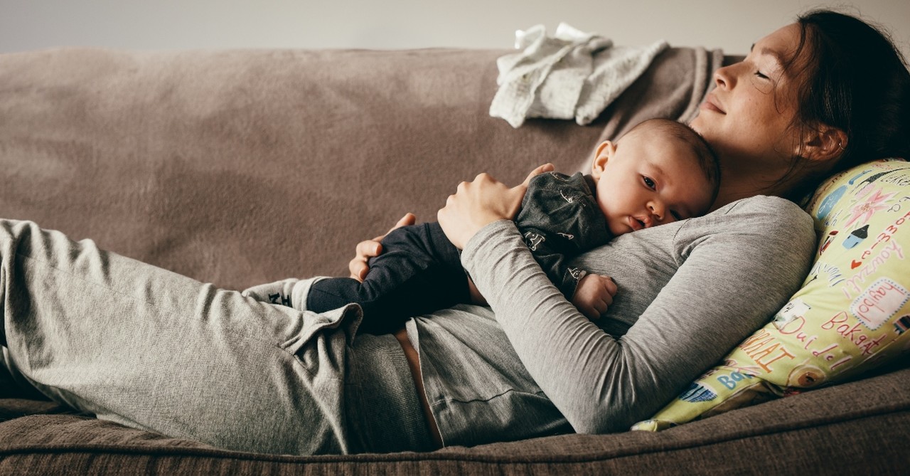 mother sleeping resting with baby on couch, parenting books that won't cause mom guilt