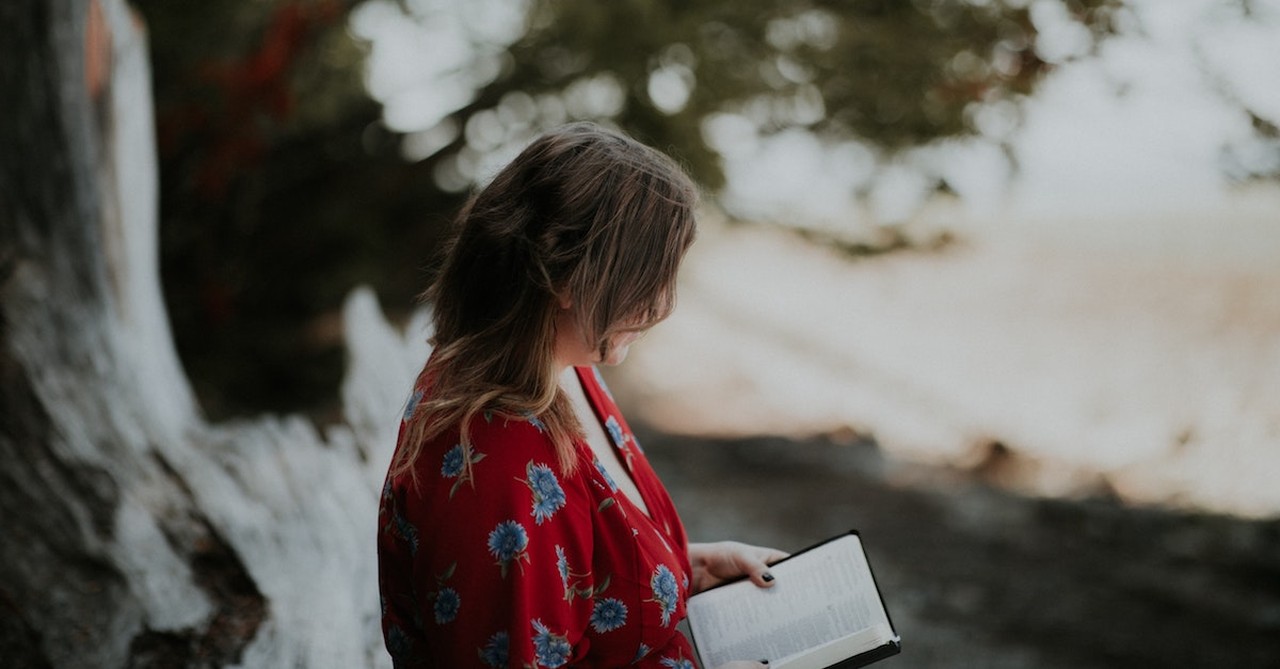 woman reading bible outside