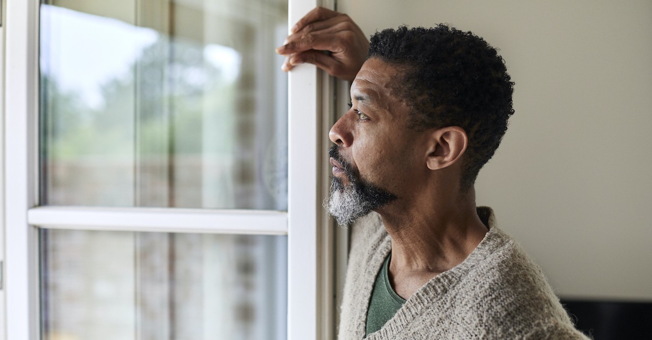 older man standing by open window and looking out, patience of Job