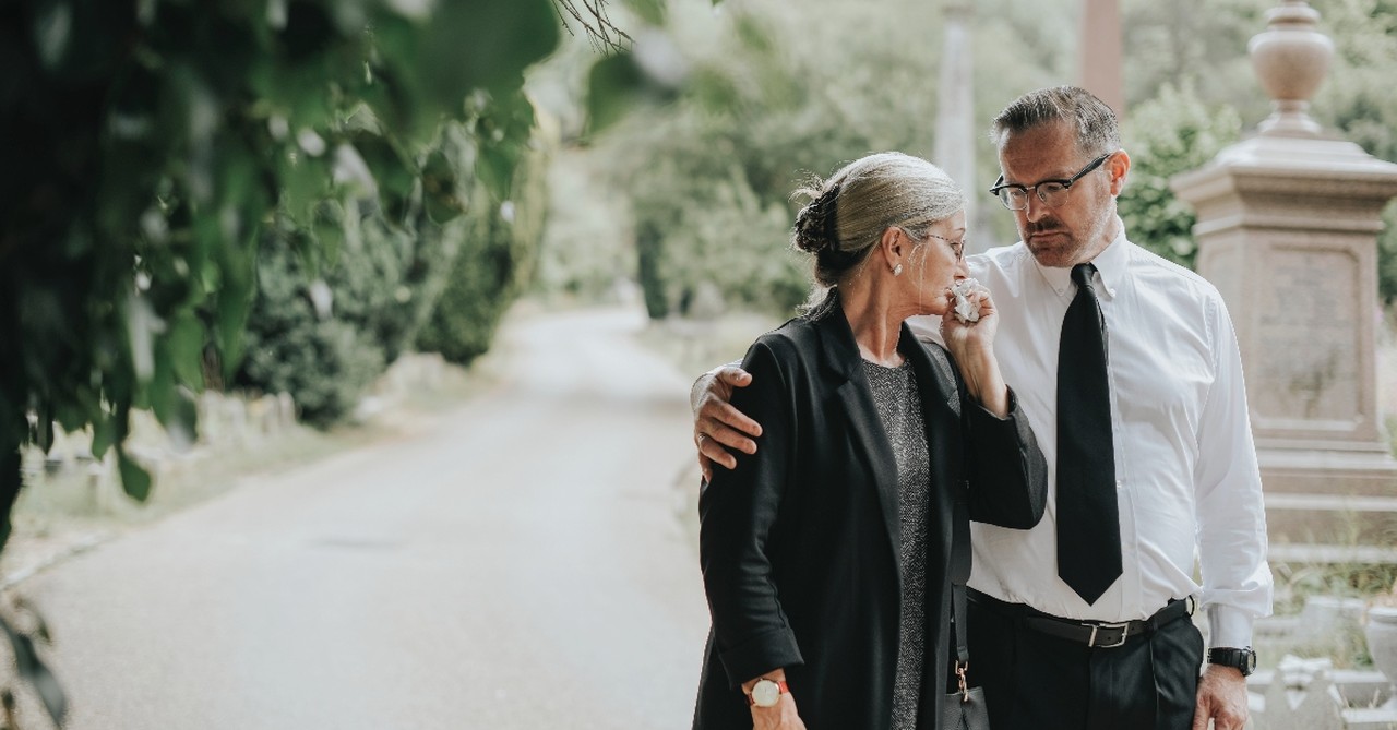 Husband and wife walking away after a funeral