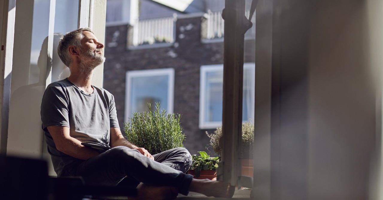 Older man sitting in a window seat relaxing