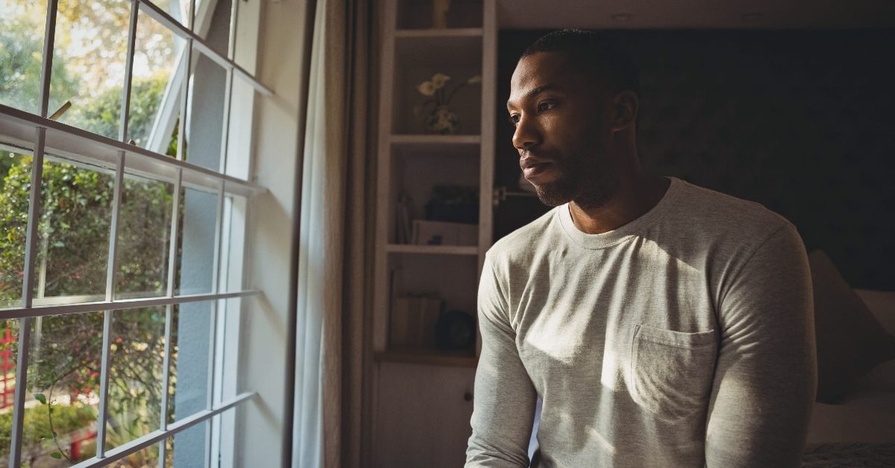 Man alone staring out the window