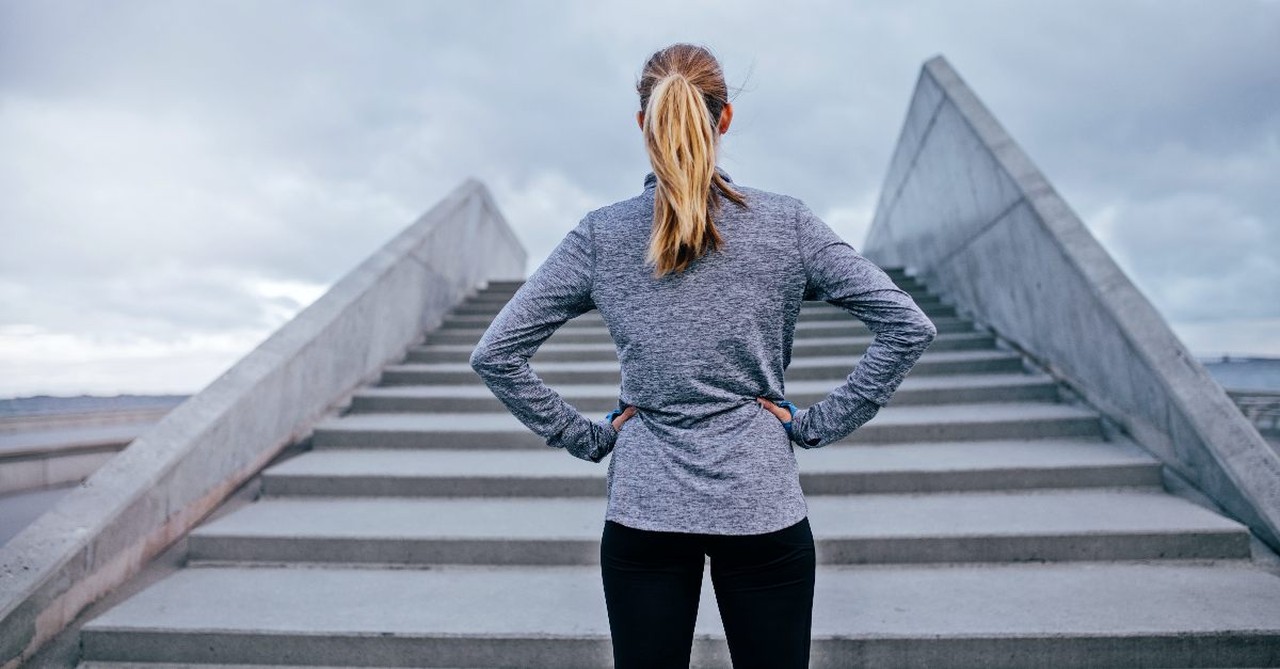 Woman waiting to to run up a set of stairs