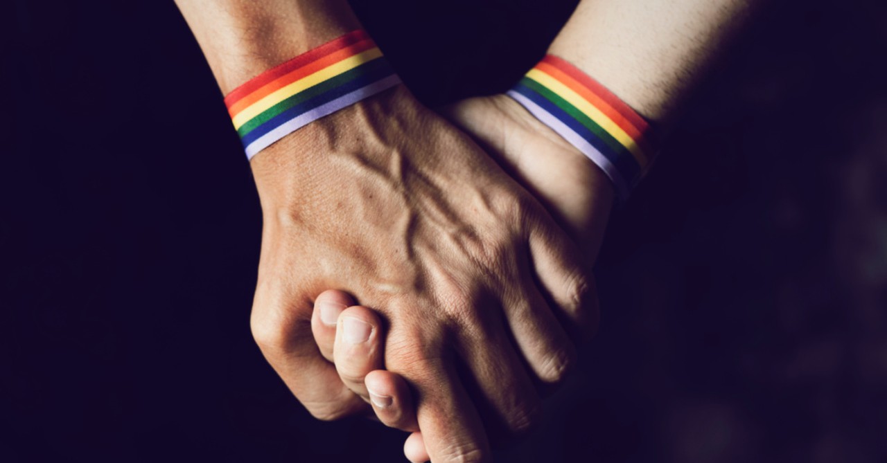 Two people holding hands and wearing rainbow bracelets, Federal court uphold Colorado Anti-discrimination law