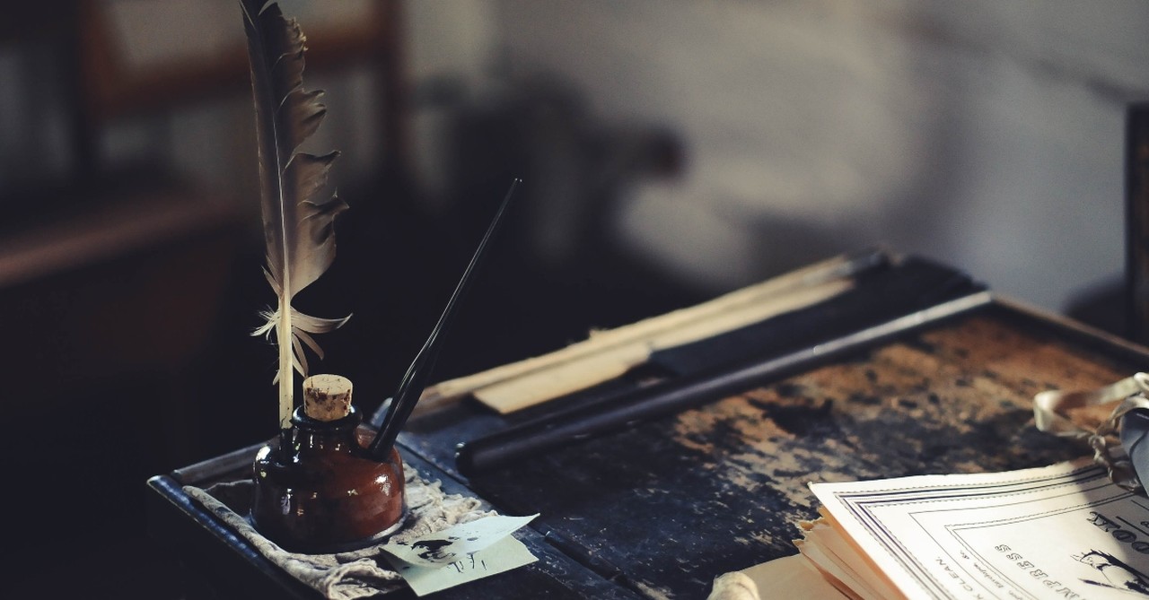 Quill and ink on an old desk