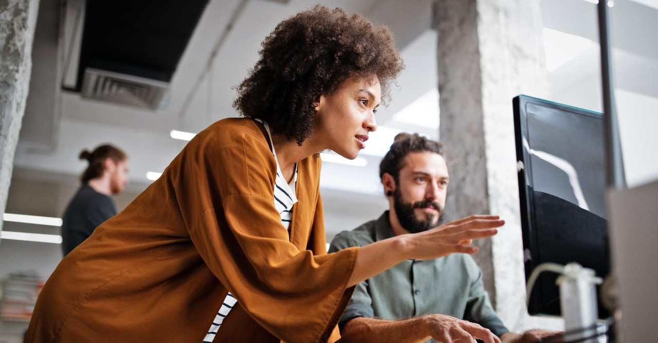 Two co-workers working together at a computer