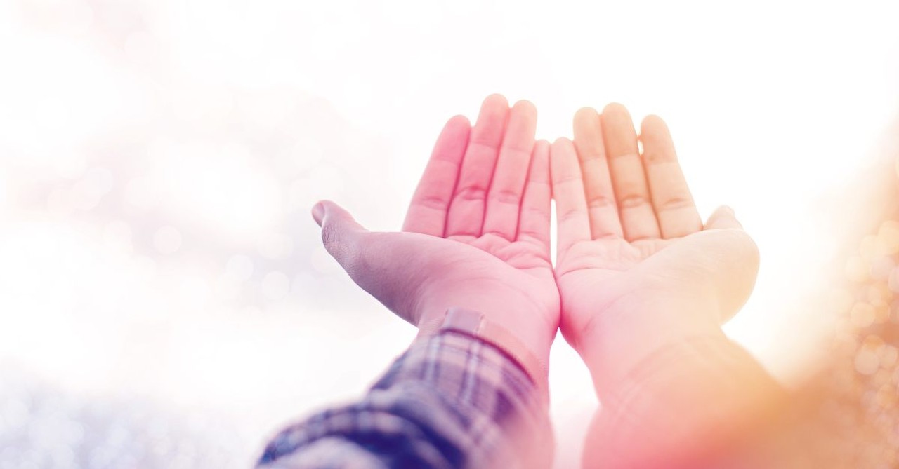 Prayer hands lifted in praise