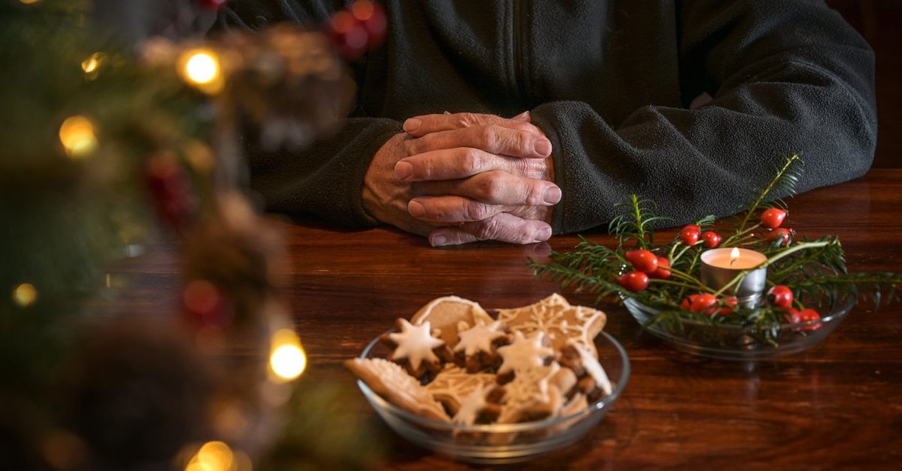 Man praying while surrounded by Christmas decorations