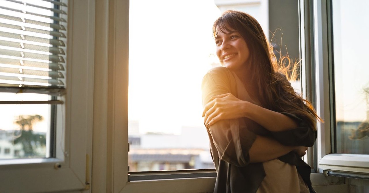 Woman peacefully looking out her window