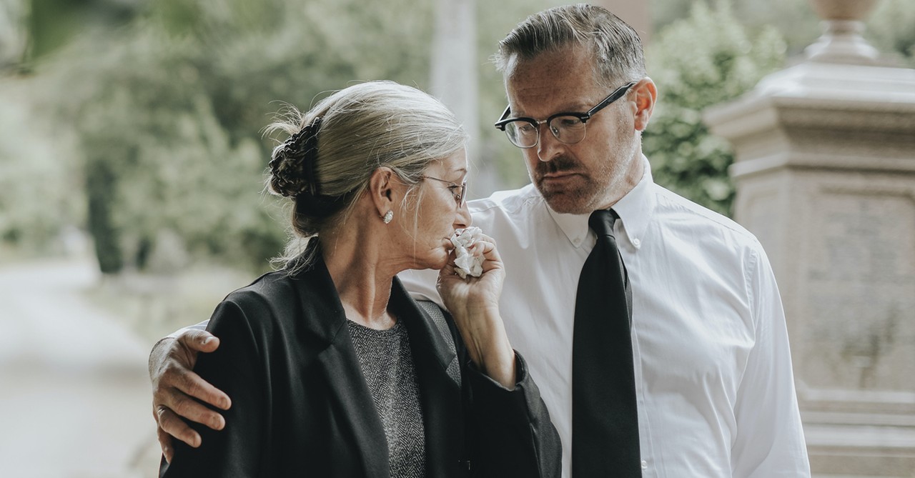 Husband and wife mourning at cemetery