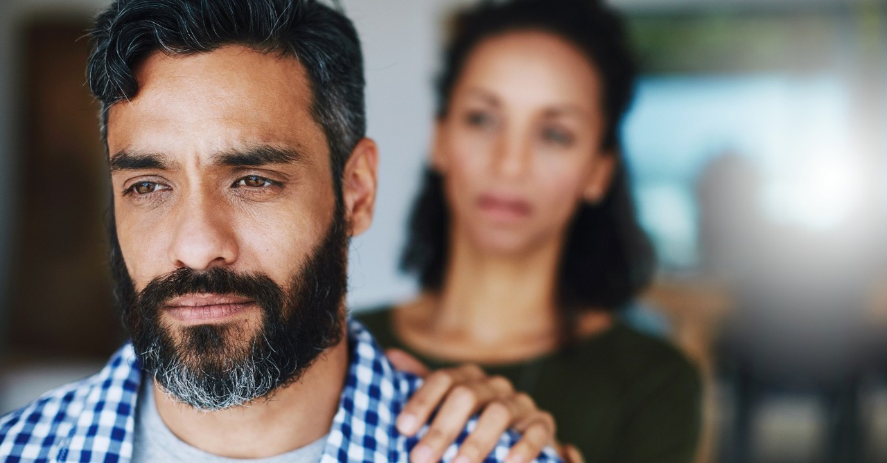 Woman with hand on man's shoulder