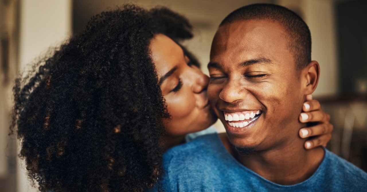 Wife happily kissing her husband on the cheek