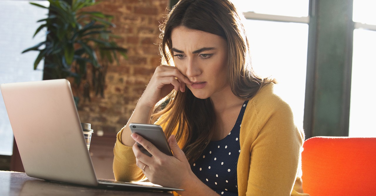 woman worrying looking at phone while siting at table