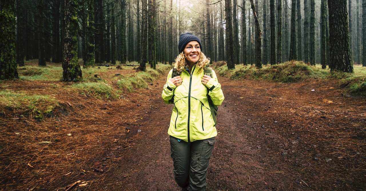 middle aged woman hiking happily in the woods, mid-life crisis