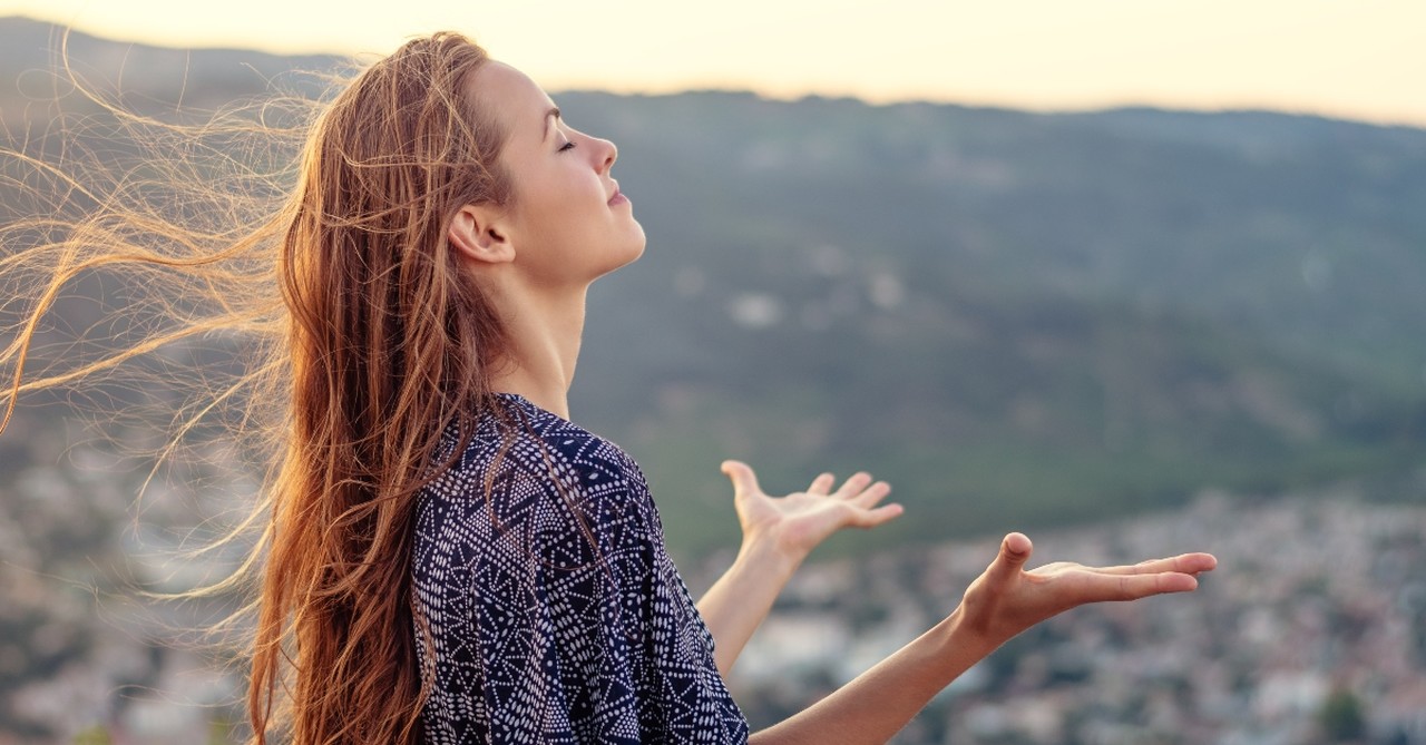 Peaceful woman raising hands