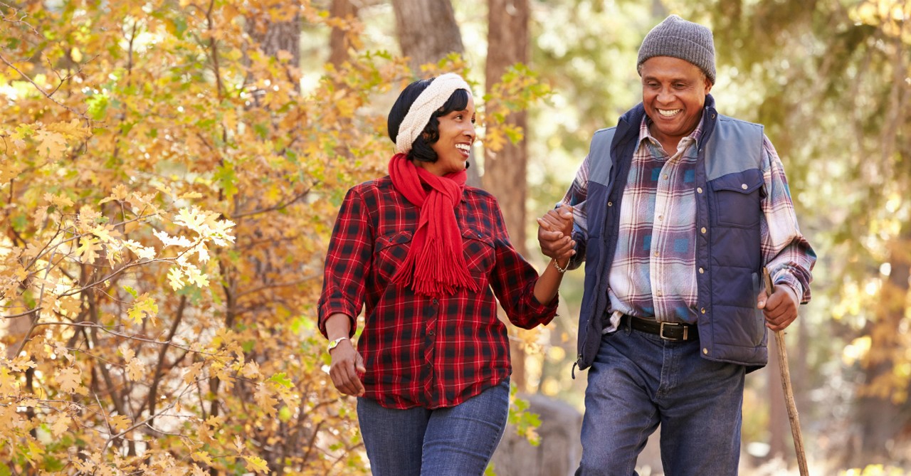 happy couple walking in nature during autumn smiling