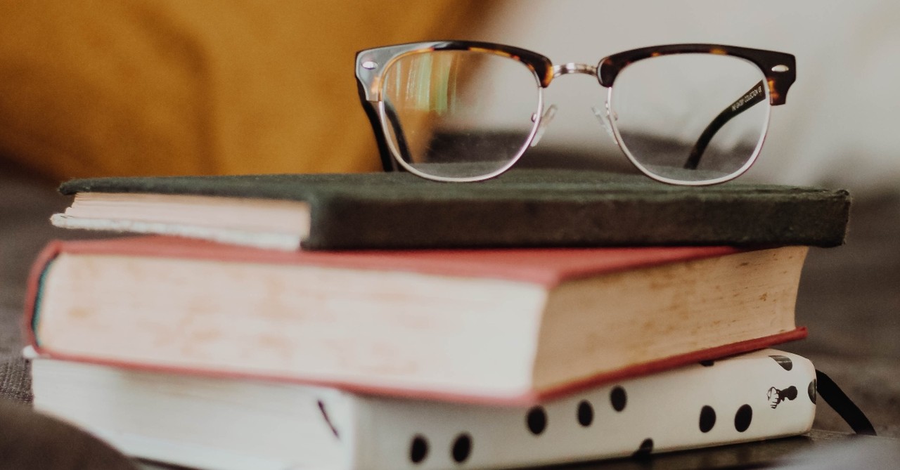 glasses on top of book pile to illusrate best christian devotional books of all time