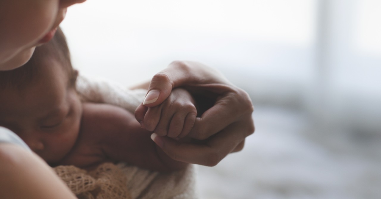 parent holding infant's hand, promises for the discouraged heart