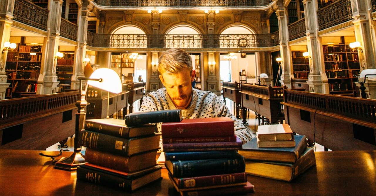 Man studying in front of a pile of books, i know the plans i have for you