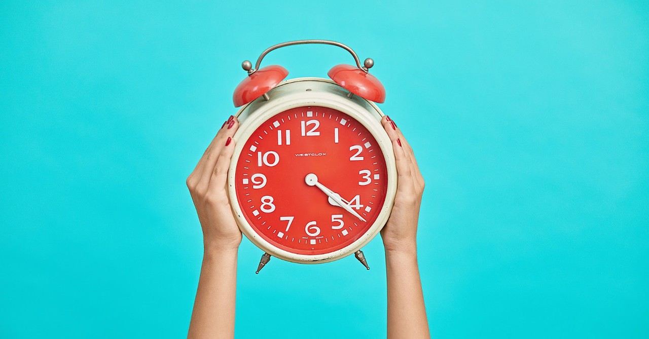 A woman holding up a clock