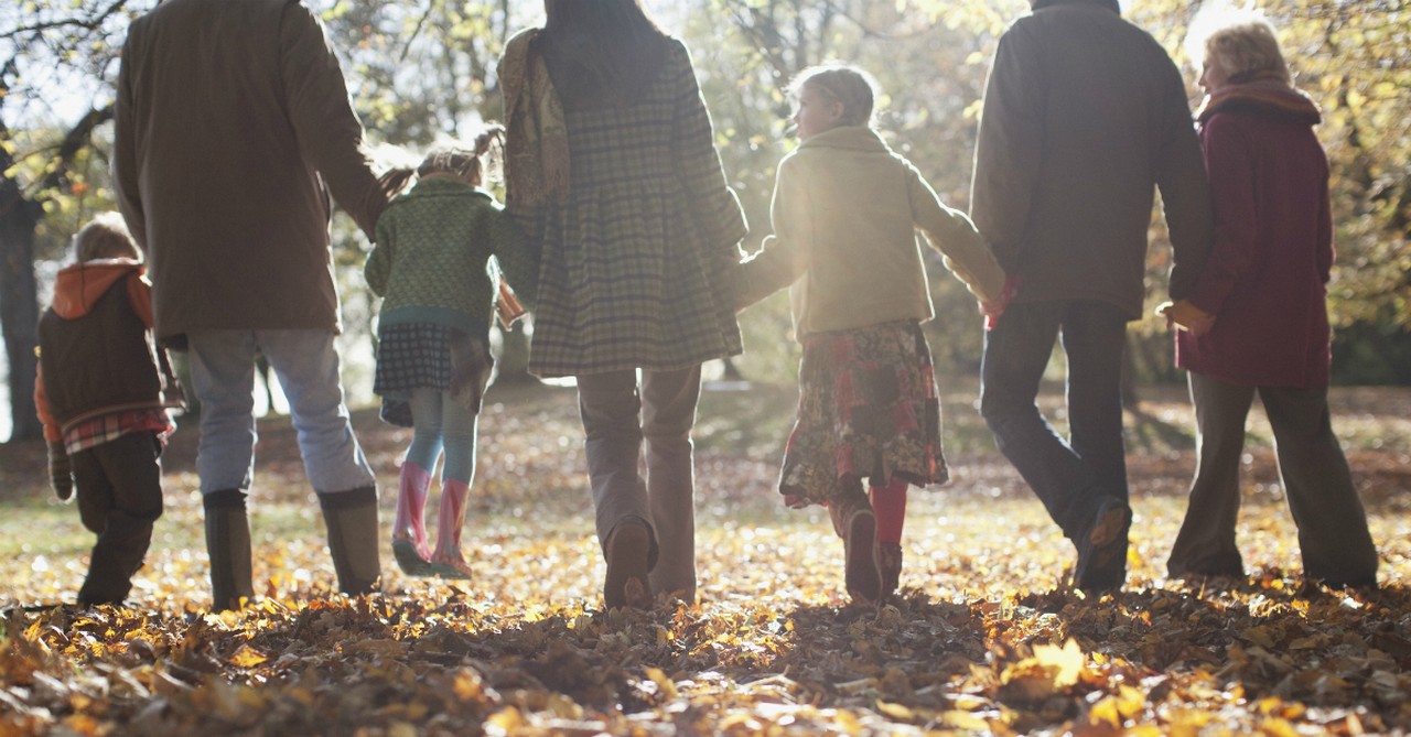 multi-generational family holding hands on a hike