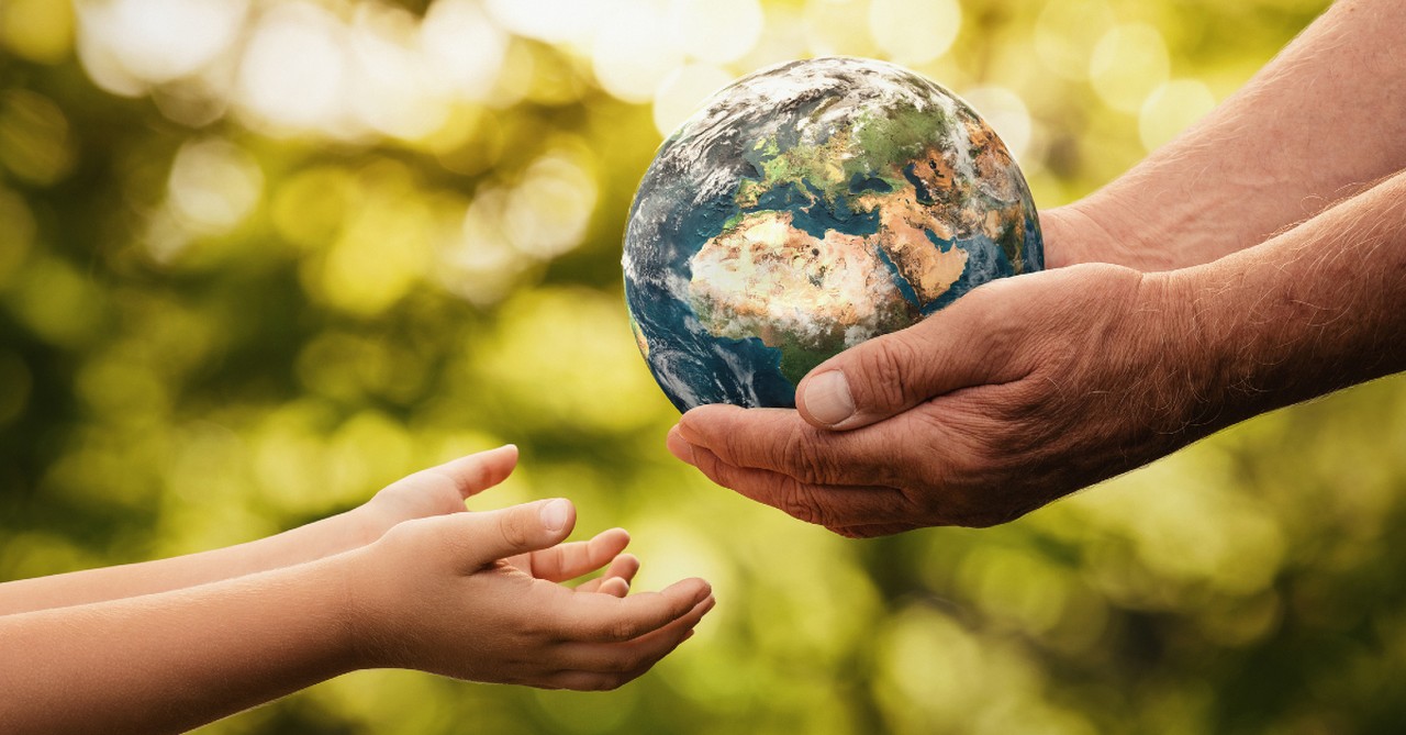 Hands passing the world onto a child