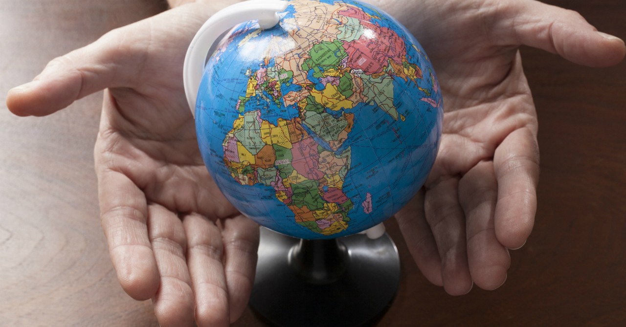 two hands holding small globe