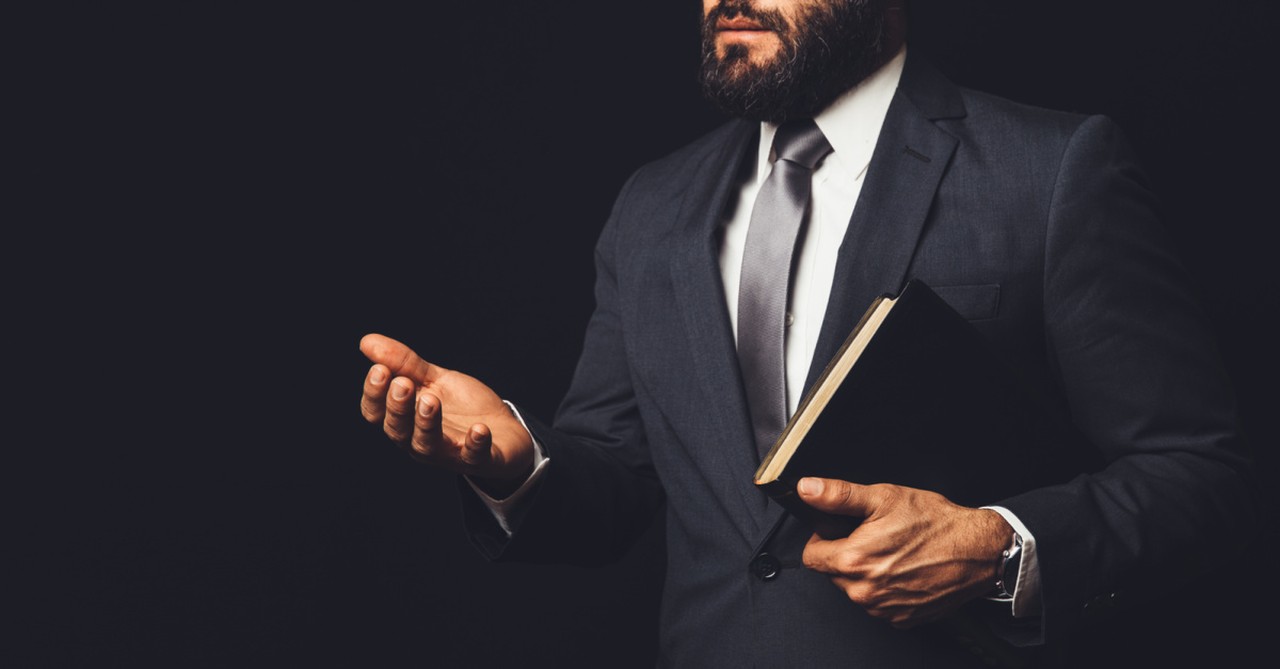 A man holding a bible and his hand out, decisions to make before leaving a church