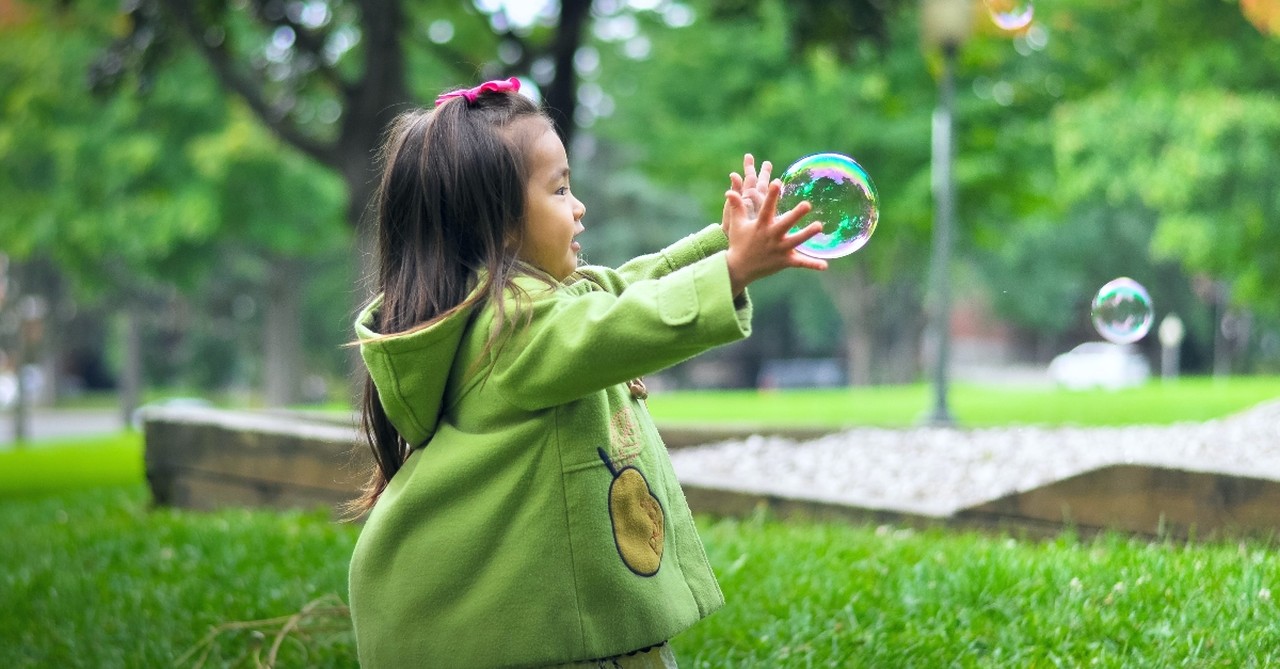 A little girl playing with bubbles