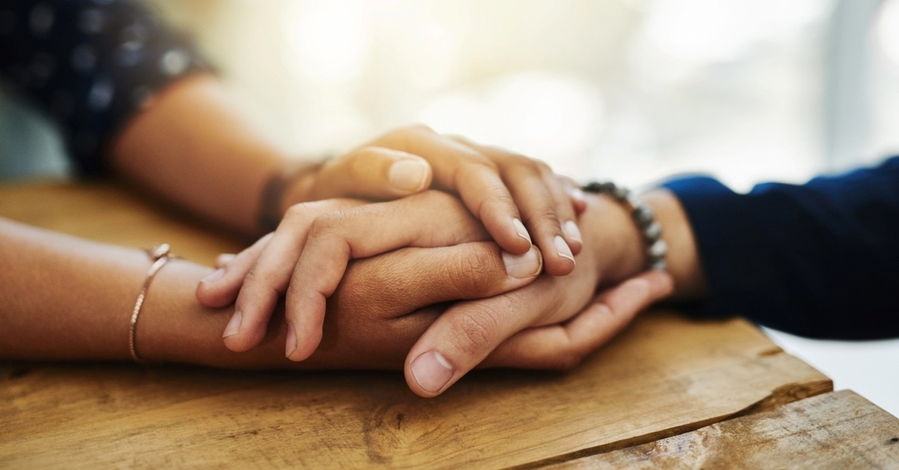 closeup two people holding hands in comfort, how to be a blessing to those who are suffering