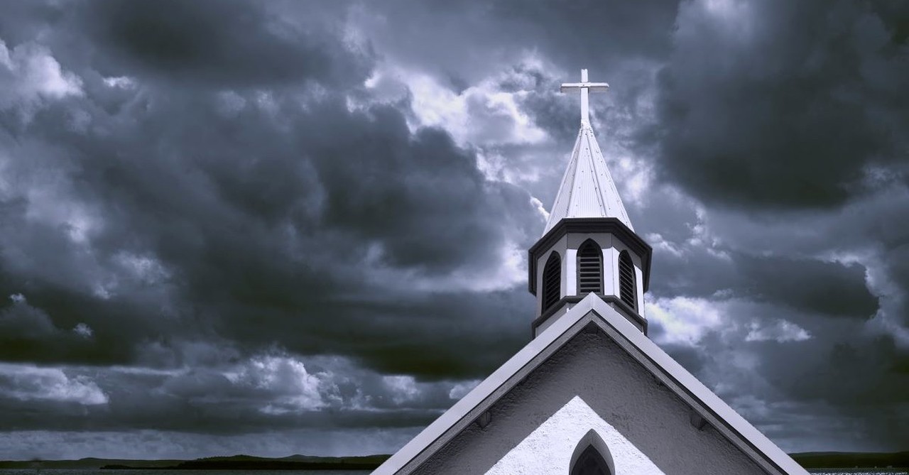 Dark church steeple against a stormy sky