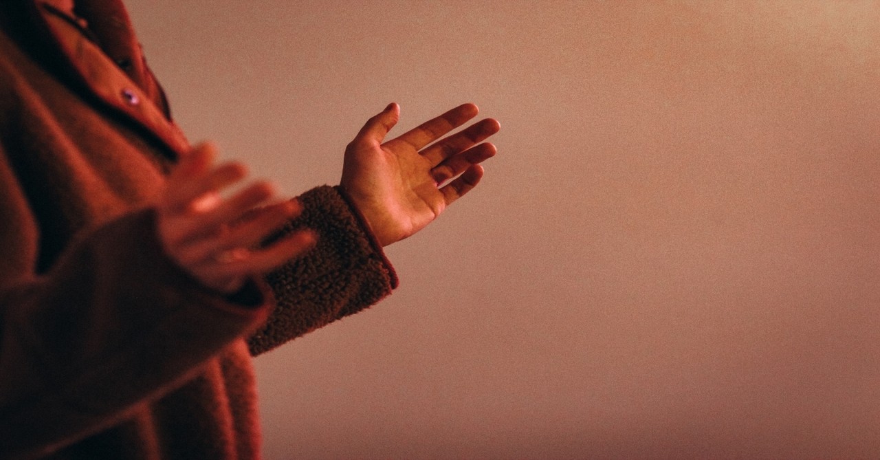 person wearing red sweater worshipping