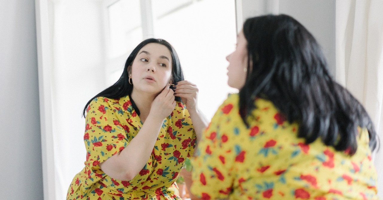 Woman looking in the mirror, getting dressed up