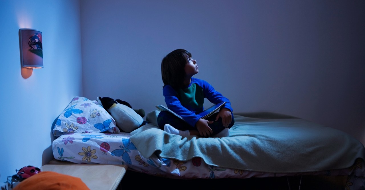 Little boy looking up in bed