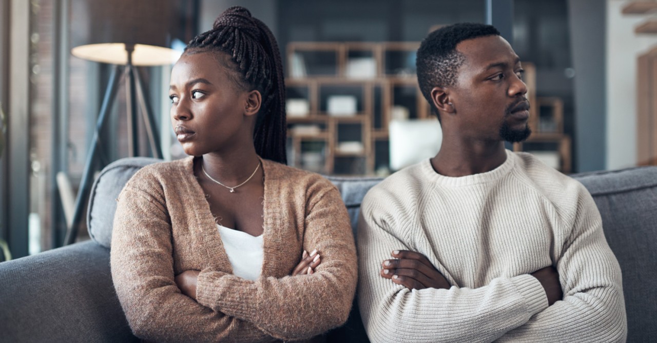 A couple with crossed arms, looking away from each other. Angry