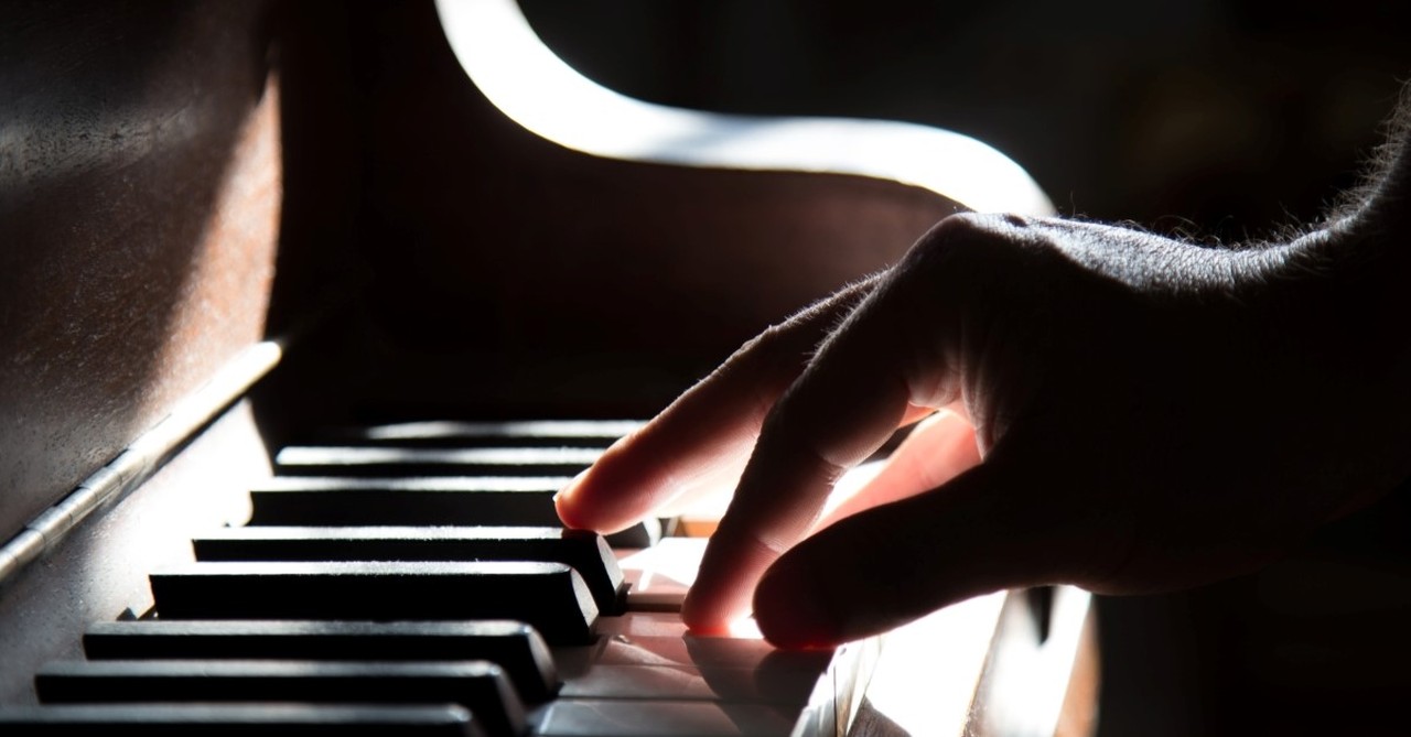 closeup man's hand playing piano