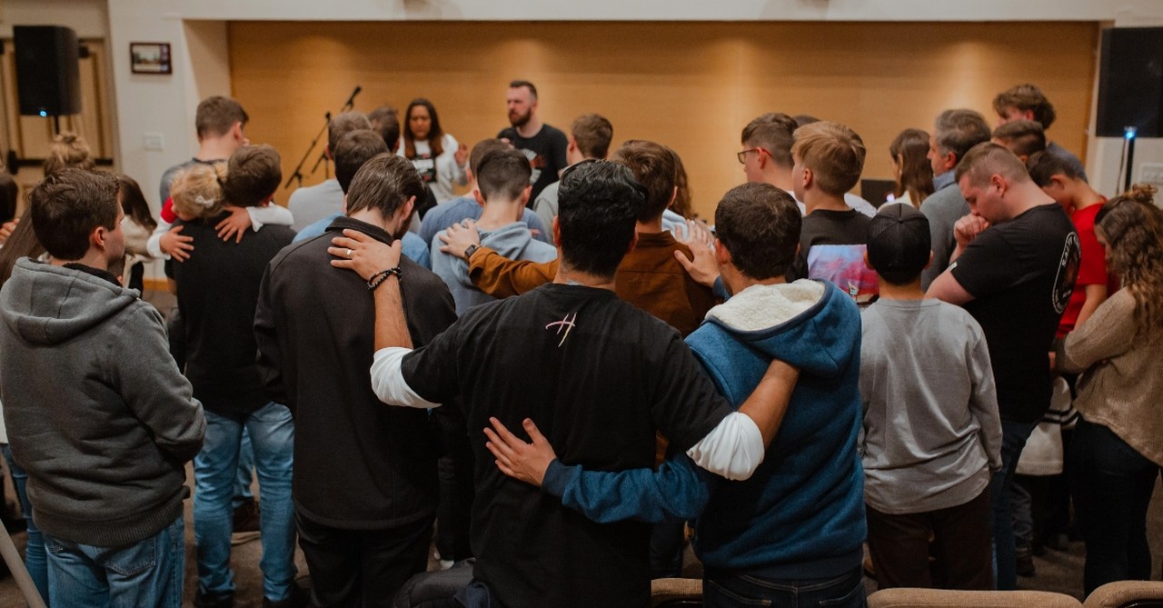 Group laying on hands, louie giglio ministry